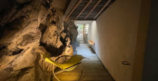 Außenterrasse bis unter der ersten Terrasse, immer noch zwischen dem Berg und dem Gebäude.