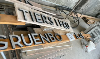 Schilder für die verschiedenen Räume der grunböx in Wien. Sie wurden mit Buchstaben von alten Schildern anderer Gebäude gestaltet.