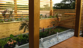 Jardinière et bassin d'eau sur la terrasse en bois.