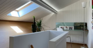 Cage d'escalier et bureau lumineux aménagé sous toiture.